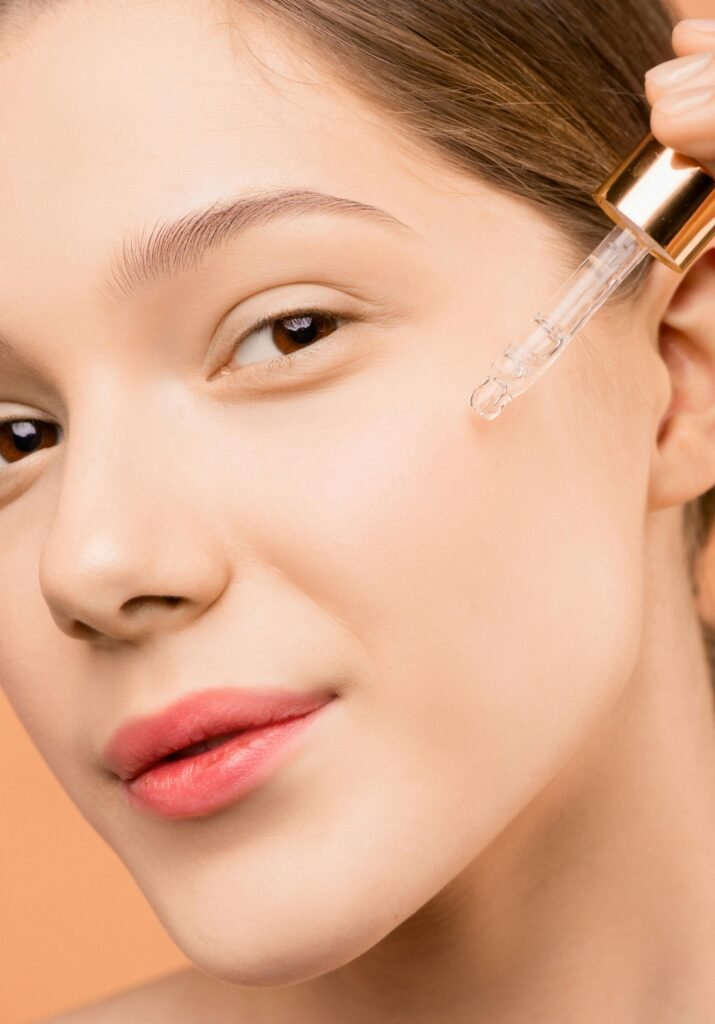 pexels-photo-3762871-3762871 A woman applying serum with a dropper to her face for skincare routine.